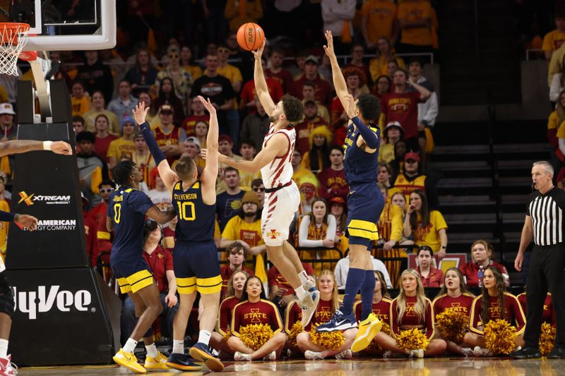 Feb 27, 2023; Ames, Iowa, USA; Iowa State Cyclones guard Gabe Kalscheur (22) scores over West Virginia Mountaineers guard Erik Stevenson (10) and West Virginia Mountaineers guard Kedrian Johnson (0) during the first half at James H. Hilton Coliseum. Mandatory Credit: Reese Strickland-USA TODAY Sports