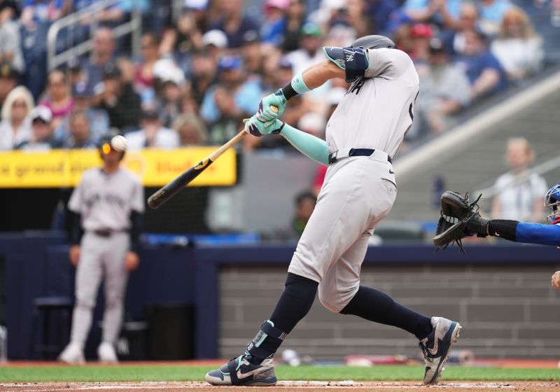 Jun 30, 2024; Toronto, Ontario, CAN; New York Yankees designated hitter Aaron Judge (99) hits a two run home run against the Toronto Blue Jays during the first inning at Rogers Centre. Mandatory Credit: Nick Turchiaro-USA TODAY Sports