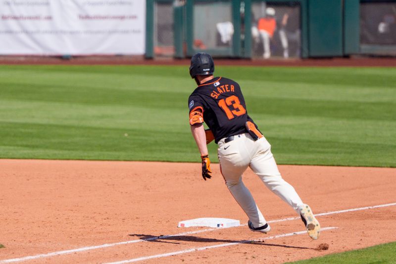 Mar 17, 2024; Scottsdale, Arizona, USA; San Francisco Giants outfielder Austin Slater (13) singles on a ground ball to right in the sixth inning during a spring training game against the Colorado Rockies at Scottsdale Stadium. Mandatory Credit: Allan Henry-USA TODAY Sports