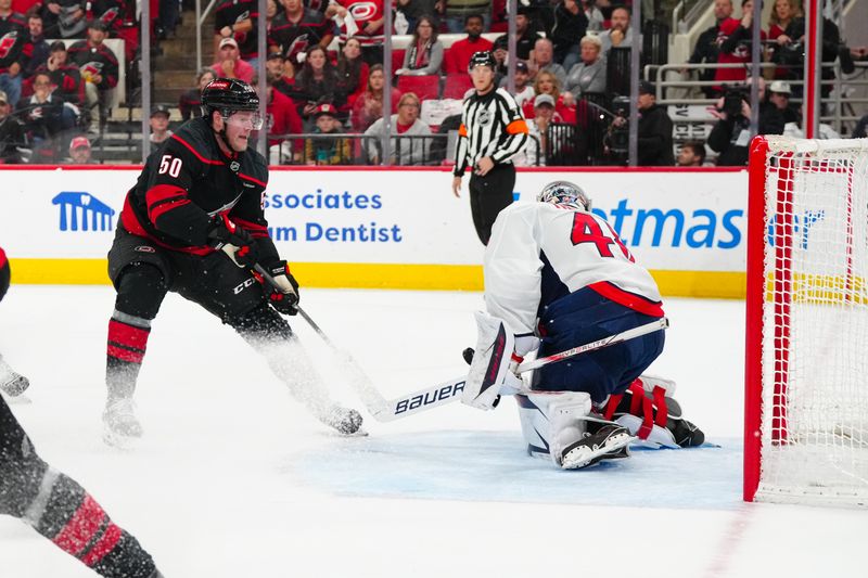 May 12, 2025; Raleigh, North Carolina, USA; Washington Capitals goaltender Logan Thompson (48) stops the scoring attempt by Carolina Hurricanes left wing Eric Robinson (50) during the first period in game four of the second round of the 2025 Stanley Cup Playoffs at Lenovo Center. Mandatory Credit: James Guillory-Imagn Images