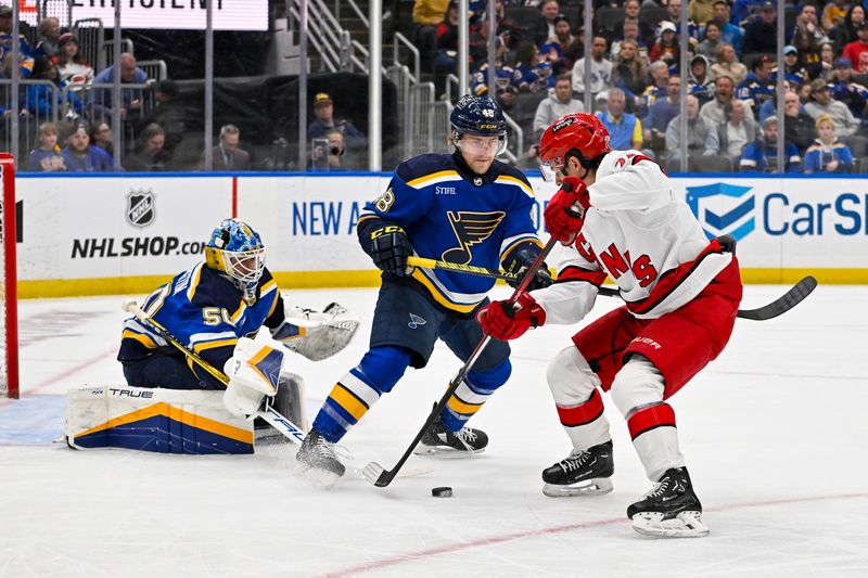 Apr 12, 2024; St. Louis, Missouri, USA;  St. Louis Blues goaltender Jordan Binnington (50) and defenseman Scott Perunovich (48) defend against Carolina Hurricanes center Seth Jarvis (24) during the first period at Enterprise Center. Mandatory Credit: Jeff Curry-USA TODAY Sports