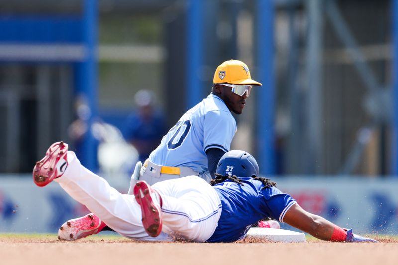 Feb 28, 2024; Dunedin, Florida, USA;  Toronto Blue Jays first baseman Vladimir Guerrero Jr. (27) slides back to second bae covered by Tampa Bay Rays second baseman Ronny Simon (70) in the first inning at TD Ballpark. Mandatory Credit: Nathan Ray Seebeck-USA TODAY Sports