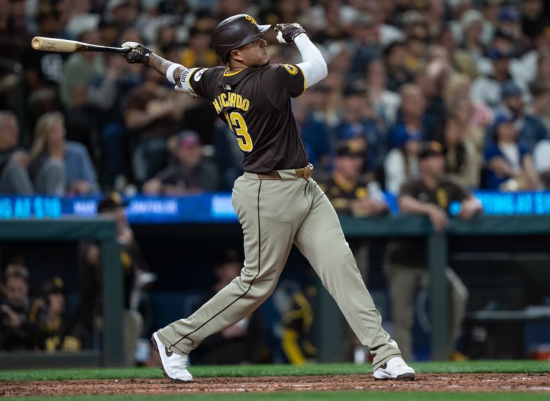 Sep 10, 2024; Seattle, Washington, USA;  San Diego Padres third baseman Manny Machado (13) hits a two-run home run during the sixth inning against the Seattle Mariners at T-Mobile Park. Mandatory Credit: Stephen Brashear-Imagn Images