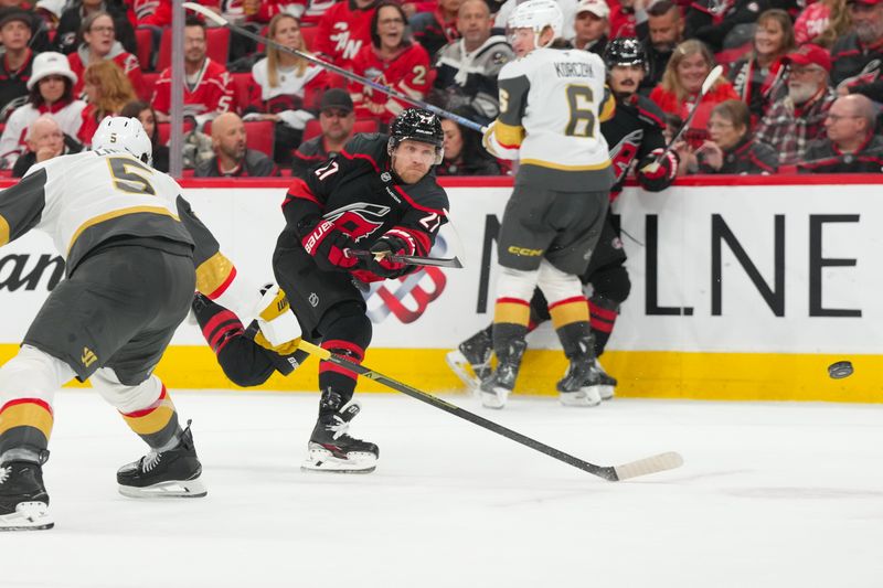 Oct 28, 2025; Raleigh, North Carolina, USA; Carolina Hurricanes left wing Nikolaj Ehlers (27) gets the shot away against Vegas Golden Knights during the third period at Lenovo Center. Mandatory Credit: James Guillory-Imagn Images