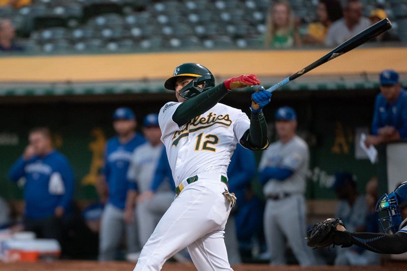 Aug 22, 2023; Oakland, California, USA; Oakland Athletics shortstop Aledmys Diaz (12) hits an rbi double during the third inning against the Kansas City Royals at Oakland-Alameda County Coliseum. Mandatory Credit: Ed Szczepanski-USA TODAY Sports