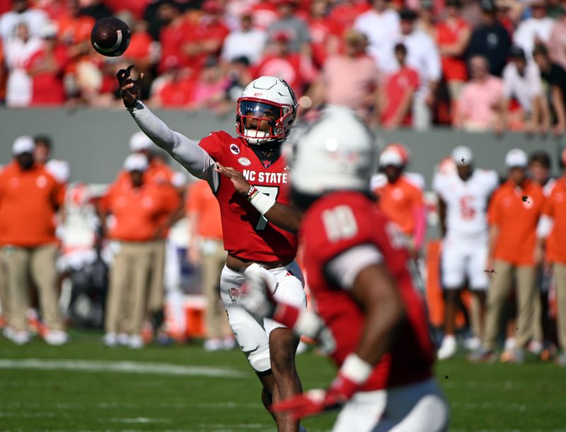 Oct 28, 2023; Raleigh, North Carolina, USA; North Carolina State Wolfpack quarterback MJ Morris (7) throws a touchdown pass to receiver KC Concepcion (10) during the first half against the Clemson Tigers at Carter-Finley Stadium. Mandatory Credit: Rob Kinnan-USA TODAY Sports