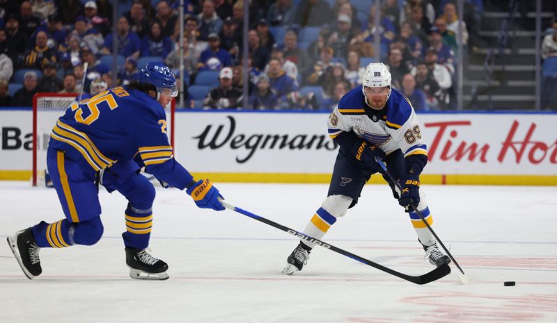 Feb 10, 2024; Buffalo, New York, USA;  Buffalo Sabres defenseman Owen Power (25) looks to knock the puck off the stick of St. Louis Blues left wing Pavel Buchnevich (89) during the third period at KeyBank Center. Mandatory Credit: Timothy T. Ludwig-USA TODAY Sports