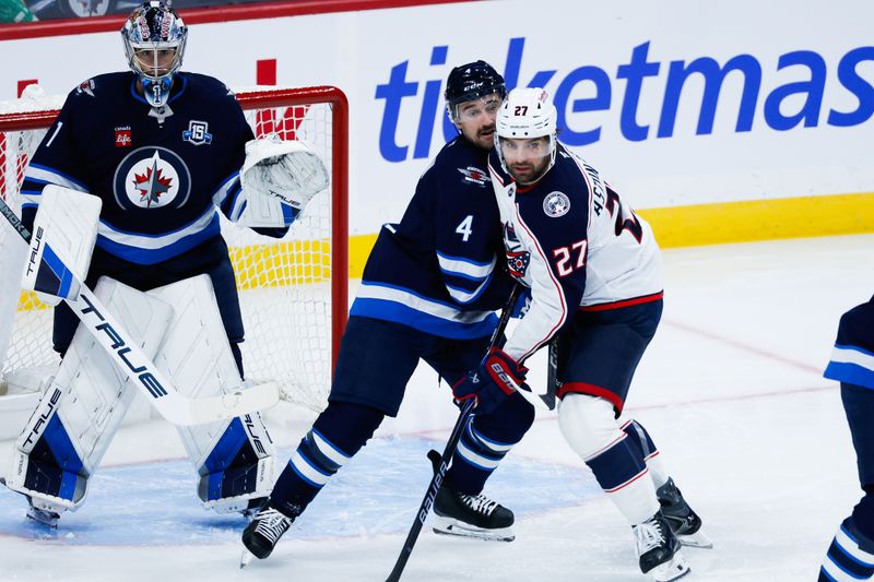 Nov 18, 2025; Winnipeg, Manitoba, CAN;  Winnipeg Jets defenseman Neal Pionk (4) jostles for position with Columbus Blue Jackets forward Zachary Aston-Reese (27) during the second period at Canada Life Centre. Mandatory Credit: Terrence Lee-Imagn Images