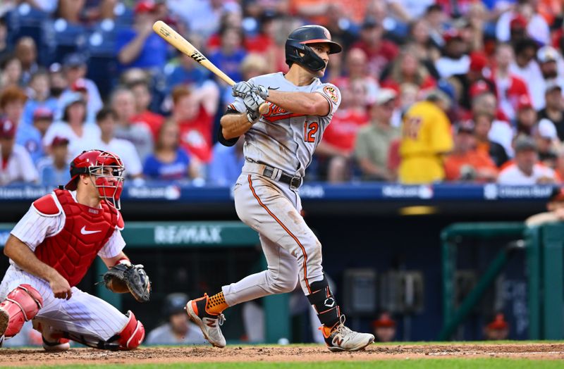 Jul 25, 2023; Philadelphia, Pennsylvania, USA; Baltimore Orioles second baseman Adam Frazier (12) hits an RBI double against the Philadelphia Phillies in the third inning at Citizens Bank Park. Mandatory Credit: Kyle Ross-USA TODAY Sports