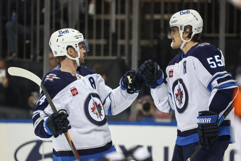 Nov 12, 2024; New York, New York, USA;  Winnipeg Jets center Mark Scheifele (55) is greeted by Winnipeg Jets defenseman Haydn Fleury (24) after scoring a goal in the first period against the New York Rangers at Madison Square Garden. Mandatory Credit: Wendell Cruz-Imagn Images