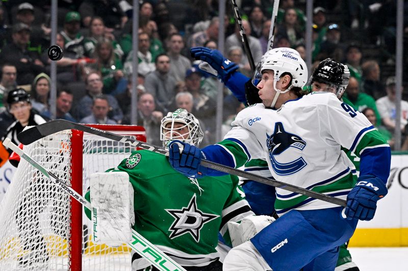 Apr 8, 2025; Dallas, Texas, USA; Vancouver Canucks center Linus Karlsson (94) attempts to poke the puck past Dallas Stars goaltender Casey DeSmith (1) during the third period at the American Airlines Center. Mandatory Credit: Jerome Miron-Imagn Images