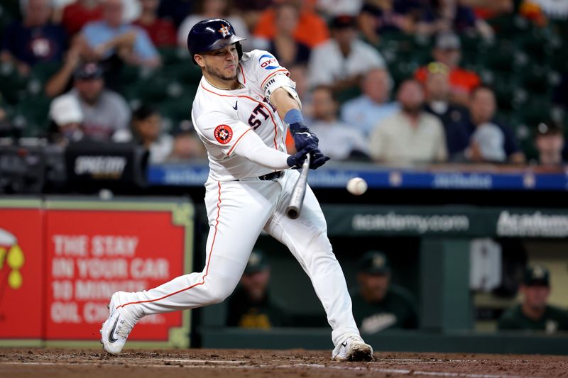 Sep 12, 2024; Houston, Texas, USA; Houston Astros catcher Yainer Diaz (21) hits a single against the Oakland Athletics during the third inning at Minute Maid Park. Mandatory Credit: Erik Williams-Imagn Images