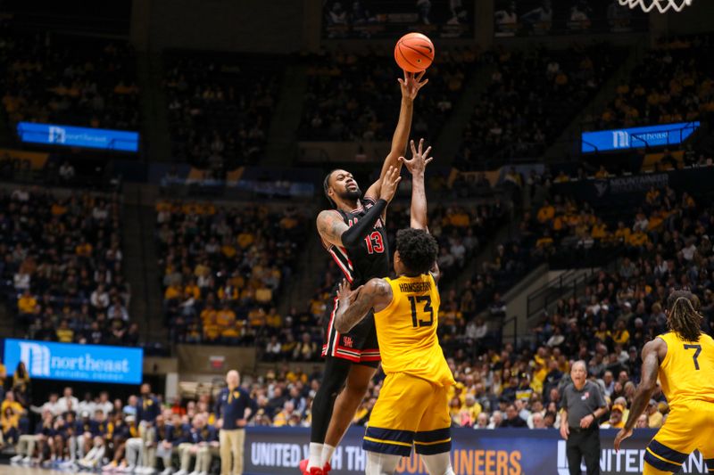 Jan 29, 2025; Morgantown, West Virginia, USA; Houston Cougars forward J'Wan Roberts (13) shoots over West Virginia Mountaineers forward Amani Hansberry (13) during the second half at WVU Coliseum. Mandatory Credit: Ben Queen-Imagn Images