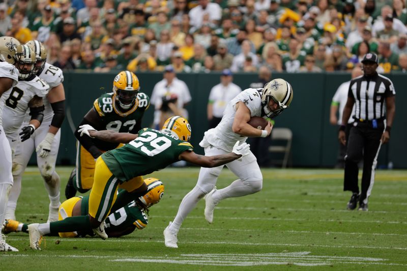 New Orleans Saints quarterback Taysom Hill (7) tries to elude the defensive pressure of Green Bay Packers cornerback Rasul Douglas (29) during an NFL football game Sunday, Sept. 24, 2023, in Green Bay, Wis. (AP Photo/Mike Roemer)