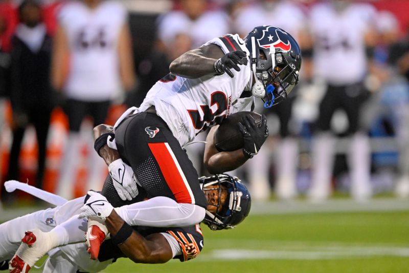 Houston Texans running back J.J. Taylor, top, is tackled by Chicago Bears cornerback Greg Stroman Jr. during the first half of an NFL exhibition Hall of Fame football game, in Canton, Ohio, Thursday, Aug. 1, 2024. (AP Photo/Gene J. Puskar)