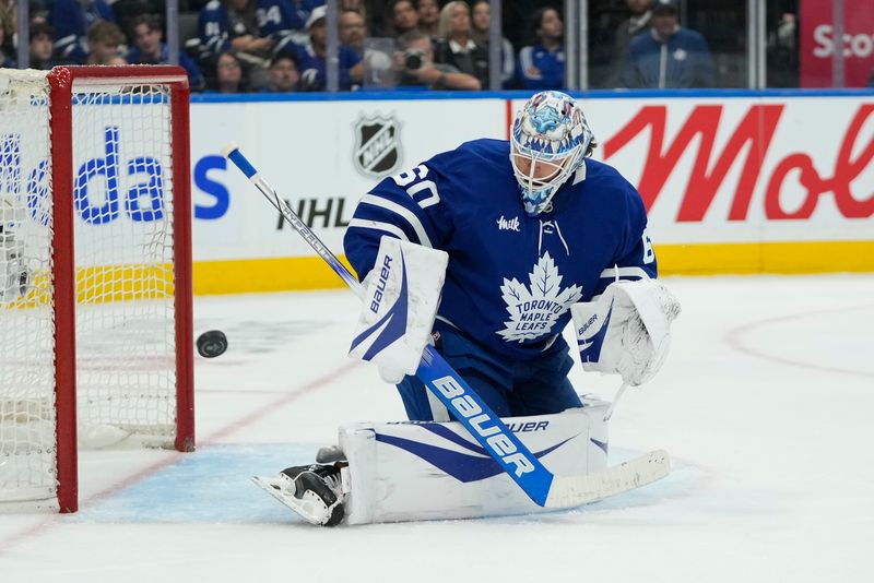 Oct 24, 2024; Toronto, Ontario, CAN; Toronto Maple Leafs goaltender Joseph Woll (60) deflects a St. Louis Blues shot wide of the goal during the second period at Scotiabank Arena. Mandatory Credit: John E. Sokolowski-Imagn Images