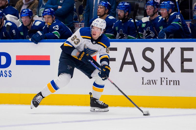 Jan 24, 2024; Vancouver, British Columbia, CAN; St. Louis Blues forward Jake Neighbours (63) handles the puck against the Vancouver Canucks in the first period at Rogers Arena. Mandatory Credit: Bob Frid-USA TODAY Sports