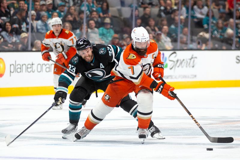 Oct 12, 2024; San Jose, California, USA; Anaheim Ducks defenseman Radio Gudas (7) brings the puck up the ice ahead of San Jose Sharks right winger Barclay Goodrow (23) during the second period at SAP Center at San Jose. Mandatory Credit: D. Ross Cameron-Imagn Images