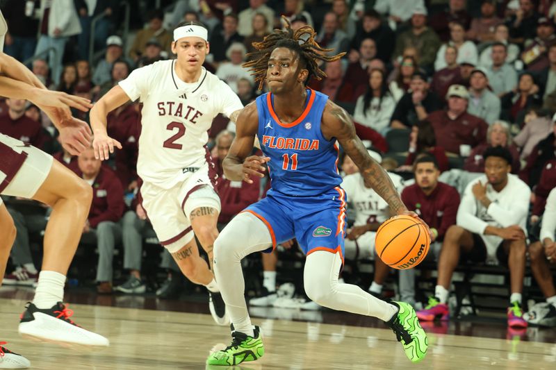 Feb 11, 2025; Starkville, Mississippi, USA; Florida Gators guard Denzel Aberdeen (11) drives against Mississippi State Bulldogs guard Riley Kugel (2) during the first half at Humphrey Coliseum. Mandatory Credit: Wesley Hale-Imagn Images