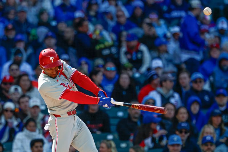 Apr 26, 2025; Chicago, Illinois, USA; Philadelphia Phillies center fielder Johan Rojas (23) hits an RBI-sacrifice fly against the Chicago Cubs during the fourth inning at Wrigley Field. Mandatory Credit: Kamil Krzaczynski-Imagn Images