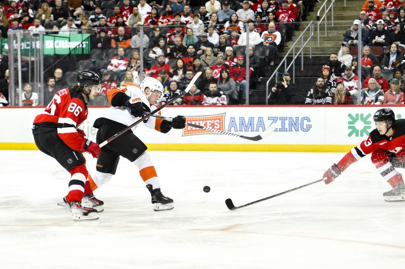 Jan 29, 2025; Newark, New Jersey, USA;  New Jersey Devils defenseman Luke Hughes (43) defends against Philadelphia Flyers right wing Matvei Michkov (39) during the second period at Prudential Center. Mandatory Credit: John Jones-Imagn Images