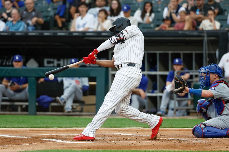 Jun 25, 2024; Chicago, Illinois, USA; Chicago White Sox designated hitter Eloy Jiménez (74) hits an RBI-double against the Los Angeles Dodgers during the first inning at Guaranteed Rate Field. Mandatory Credit: Kamil Krzaczynski-USA TODAY Sports