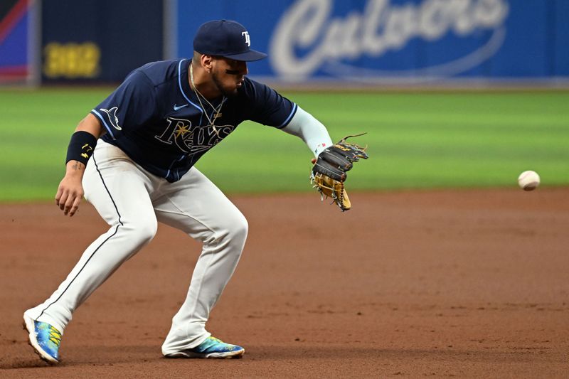 Jun 11, 2024; St. Petersburg, Florida, USA; Tampa Bay Rays third baseman Isaac Paredes (17) fields a ground ball in the second inning against the Chicago Cubs at Tropicana Field. Mandatory Credit: Jonathan Dyer-USA TODAY Sports