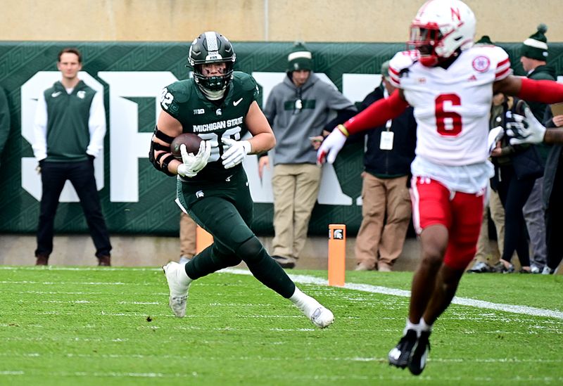 Nov 4, 2023; East Lansing, Michigan, USA; Michigan State Spartans tight end Brennan Parachek (82) runs upfield behind the back of Nebraska Cornhuskers defensive back Quinton Newsome (6) in the first quarter at Spartan Stadium. Mandatory Credit: Dale Young-USA TODAY Sports