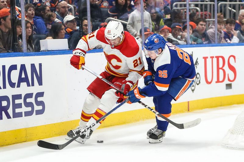 Feb 10, 2024; Elmont, New York, USA;  Calgary Flames center Kevin Rooney (21) and New York Islanders defenseman Sebastian Aho (25) battle for control of the puck in the third period at UBS Arena. Mandatory Credit: Wendell Cruz-USA TODAY Sports