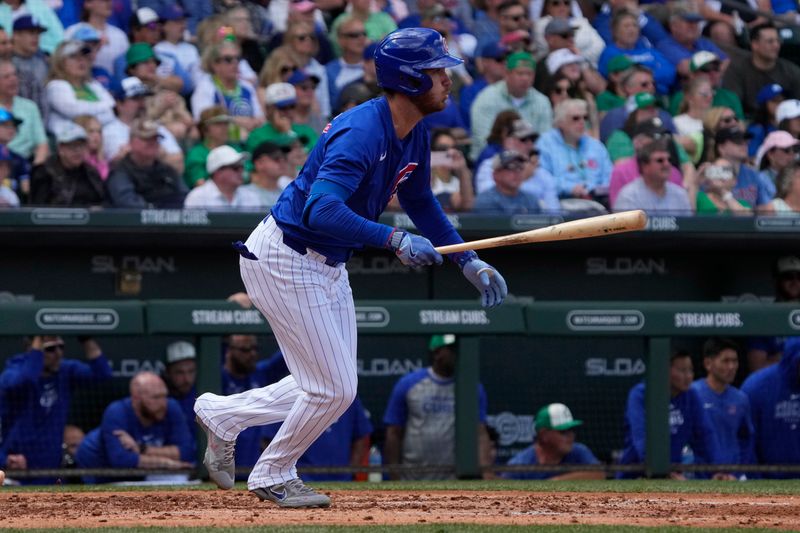 Mar 17, 2024; Mesa, Arizona, USA; Chicago Cubs centerfielder Cody Bellinger (24) hits a single in the third inning during a game against the Texas Rangers at Sloan Park. Mandatory Credit: Rick Scuteri-USA TODAY Sports