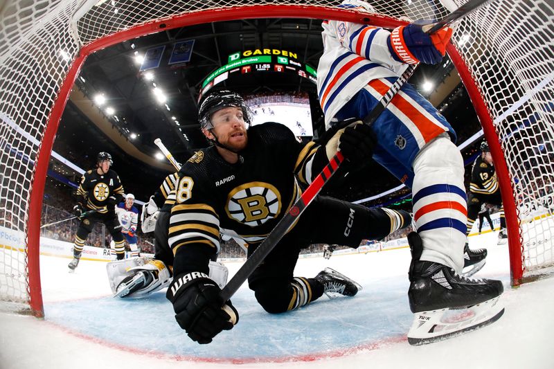 Mar 5, 2024; Boston, Massachusetts, USA; Boston Bruins defenseman Matt Grzelcyk (48) is dumped into his own net by Edmonton Oilers left wing Zach Hyman (18) during the third period at TD Garden. Mandatory Credit: Winslow Townson-USA TODAY Sports