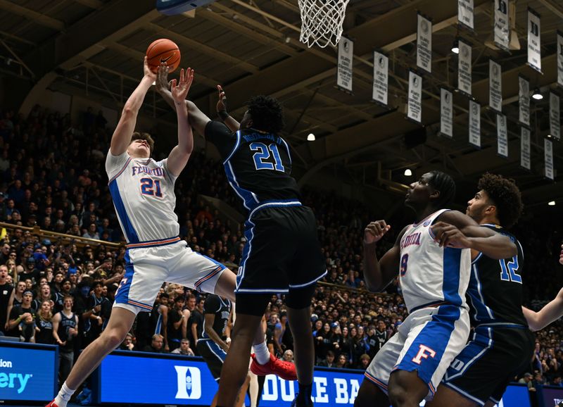 Dec 2, 2025; Durham, North Carolina, USA; Duke Blue Devils center Patrick Ngongba II (21) blocks the shot of Florida Gators forward/center Alex Condon (21) during the first half at Cameron Indoor Stadium. Mandatory Credit: Rob Kinnan-Imagn Images