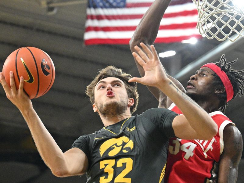 Feb 2, 2024; Iowa City, Iowa, USA; Iowa Hawkeyes forward Owen Freeman (32) goes to the basket as Ohio State Buckeyes center Felix Okpara (34) defends during the second half at Carver-Hawkeye Arena. Mandatory Credit: Jeffrey Becker-USA TODAY Sports