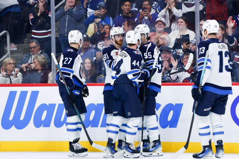 Oct 28, 2024; Winnipeg, Manitoba, CAN;  Winnipeg Jets forward Kyle Connor (81) is congratulated by his team mates on his goal against the Toronto Maple Leafs during the second period at Canada Life Centre. Mandatory Credit: Terrence Lee-Imagn Images