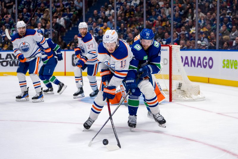 May 20, 2024; Vancouver, British Columbia, CAN; Vancouver Canucks forward Elias Lindholm (23) stick checks Edmonton Oilers forward Mattias Janmark (13) during the third period in game seven of the second round of the 2024 Stanley Cup Playoffs at Rogers Arena. Mandatory Credit: Bob Frid-USA TODAY Sports