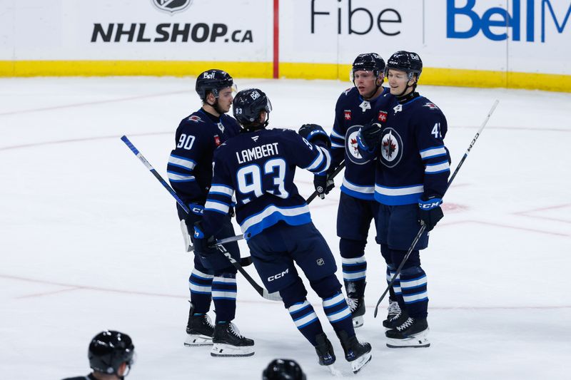 Oct 2, 2024; Winnipeg, Manitoba, CAN;  Winnipeg Jets defenseman Simon Lundmark (42) is congratulated by his team mates on his goal against Calgary Flames goalie Dustin Wolf (32) during the third period at Canada Life Centre. Mandatory Credit: Terrence Lee-Imagn Images