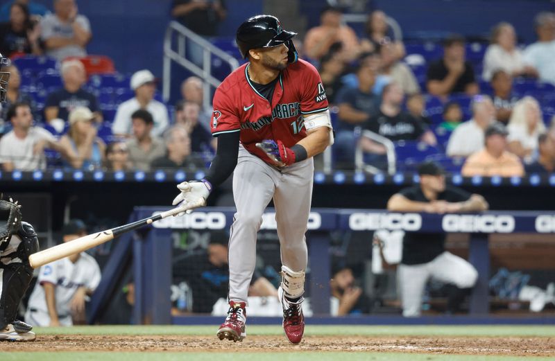 Aug 21, 2024; Miami, Florida, USA;  Arizona Diamondbacks left fielder Lourdes Gurriel Jr. (12) doubles against the Miami Marlins in the seventh inning at loanDepot Park. Mandatory Credit: Rhona Wise-USA TODAY Sports