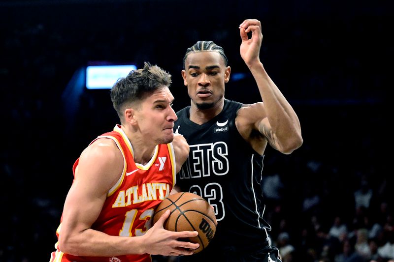 NEW YORK, NEW YORK - FEBRUARY 29:  Bogdan Bogdanovic #13 of the Atlanta Hawks drives to the basket against Nic Claxton #33 of the Brooklyn Nets during the first half at Barclays Center on February 29, 2024 in New York City. NOTE TO USER: User expressly acknowledges and agrees that, by downloading and or using this photograph, User is consenting to the terms and conditions of the Getty Images License Agreement. (Photo by Steven Ryan/Getty Images)