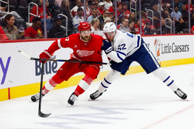 Oct 3, 2024; Detroit, Michigan, USA;  Detroit Red Wings center Michael Rasmussen (27) and Toronto Maple Leafs defenseman Cade Webber (52) battle for the puck in the second period at Little Caesars Arena. Mandatory Credit: Rick Osentoski-Imagn Images