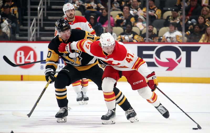 Nov 30, 2024; Pittsburgh, Pennsylvania, USA;  Calgary Flames center Connor Zary (47) moves the puck up ice against Pittsburgh Penguins left wing Drew O'Connor (10) during the second period at PPG Paints Arena. Mandatory Credit: Charles LeClaire-Imagn Images