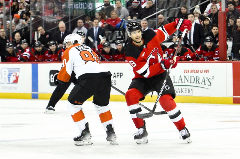 Jan 29, 2025; Newark, New Jersey, USA; New Jersey Devils defenseman Johnathan Kovacevic (8) passes the puck as Philadelphia Flyers center Anthony Richard (90) defends during the first period at Prudential Center. Mandatory Credit: John Jones-Imagn Images