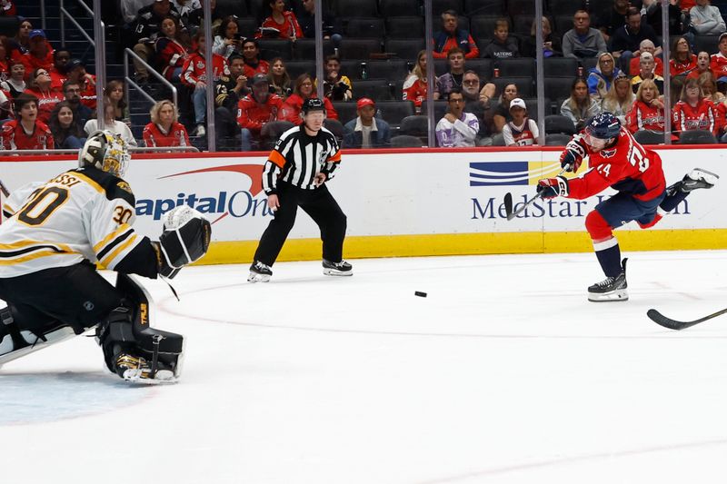 Oct 5, 2024; Washington, District of Columbia, USA; Washington Capitals center Connor McMichael (24) shoots the puck on Boston Bruins goaltender Brandon Bussi (30) in the third period at Capital One Arena. Mandatory Credit: Geoff Burke-Imagn Images