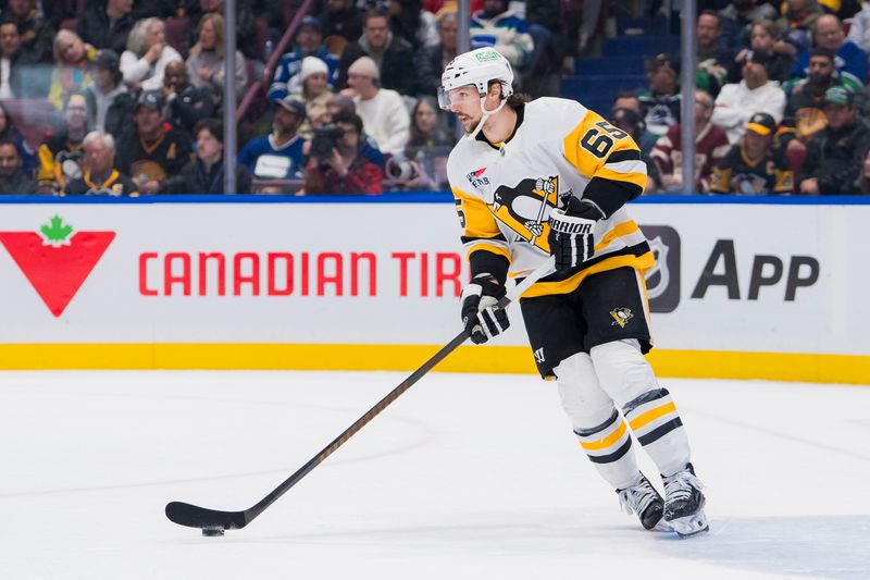 Feb 27, 2024; Vancouver, British Columbia, CAN; Pittsburgh Penguins defenseman Erik Karlsson (65) handles the puck against the Vancouver Canucks in the third period at Rogers Arena. Penguins won 4-3 in overtime. Mandatory Credit: Bob Frid-USA TODAY Sports