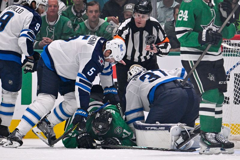 May 13, 2025; Dallas, Texas, USA; Winnipeg Jets defenseman Luke Schenn (5) holds down Dallas Stars left wing Jason Robertson (21) as goaltender Connor Hellebuyck (37) covers the puck during the third period in game four of the second round of the 2025 Stanley Cup Playoffs at American Airlines Center. Mandatory Credit: Jerome Miron-Imagn Images