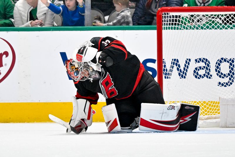 Jan 25, 2023; Dallas, Texas, USA; Carolina Hurricanes goaltender Antti Raanta (32) grabs his neck as he falls to the ice after apparently getting hit with a stick during the third period against the Dallas Stars at the American Airlines Center. Mandatory Credit: Jerome Miron-USA TODAY Sports