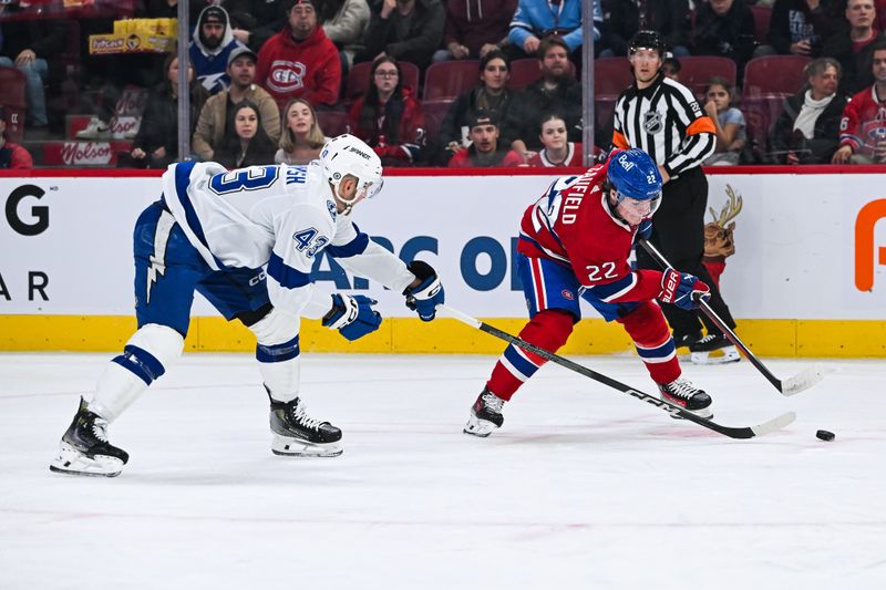 Apr 4, 2024; Montreal, Quebec, CAN; Montreal Canadiens right wing Cole Caufield (22) plays the puck against Tampa Bay Lightning defenseman Darren Raddysh (43) during the first period at Bell Centre. Mandatory Credit: David Kirouac-USA TODAY Sports