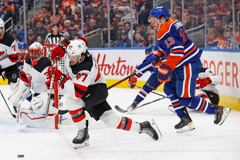 Nov 4, 2024; Edmonton, Alberta, CAN; New Jersey Devils forward Paul Cotter (47) clears the puck in front of Edmonton Oilers forward Mattias Janmark (13) during the third period at Rogers Place. Mandatory Credit: Perry Nelson-Imagn Images