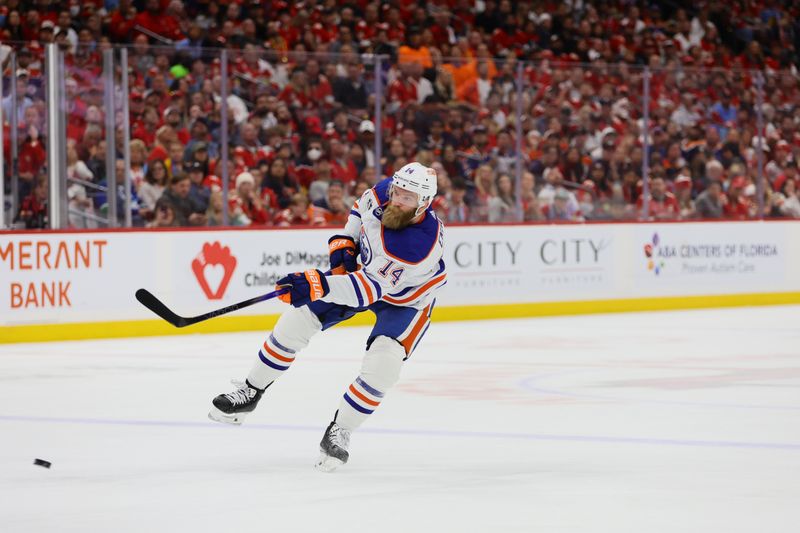 Jun 24, 2024; Sunrise, Florida, USA; Edmonton Oilers defenseman Mattias Ekholm (14) shoots the puck during the first period against the Florida Panthers in game seven of the 2024 Stanley Cup Final at Amerant Bank Arena. Mandatory Credit: Sam Navarro-USA TODAY Sports