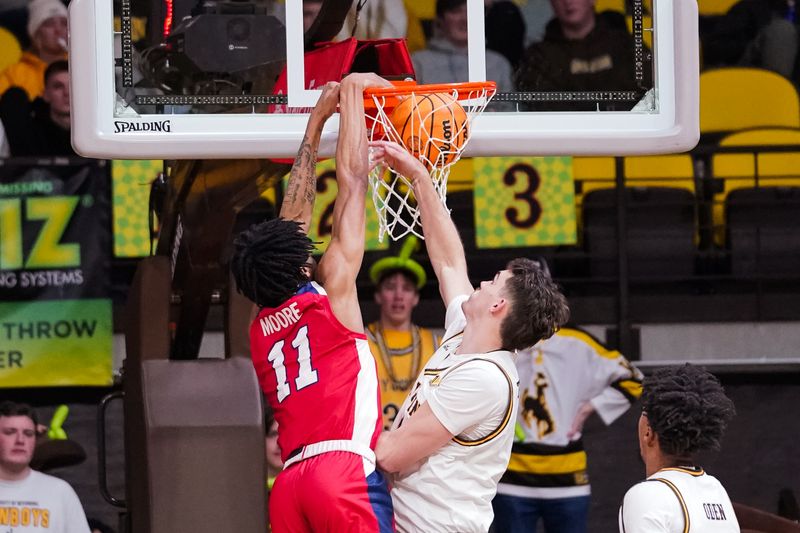 Jan 31, 2023; Laramie, Wyoming, USA; Fresno State Bulldogs forward Isaih Moore (11) dunks over Wyoming Cowboys forward Hunter Thompson (10) during the second half against the Fresno State Bulldogs at Arena-Auditorium. Mandatory Credit: Troy Babbitt-USA TODAY Sports