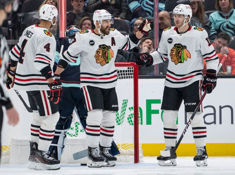 Jan 24, 2024; Seattle, Washington, USA; Chicago Blackhawks forward Nick Foligno (17) celebrates a power play goal with defenseman Seth Jones (4) and forward Taylor Raddysh (11) during the third period at Climate Pledge Arena. Mandatory Credit: Stephen Brashear-USA TODAY Sports